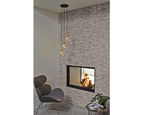 Woonkamer met open haard, fauteuil en hanglamp