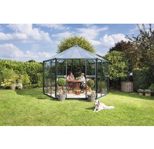 Tuinpaviljoen met moeder en kind aan een tafel en een hond in de tuin.