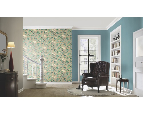 Woonkamer met bloemmotief behang, fauteuil en boekenkast