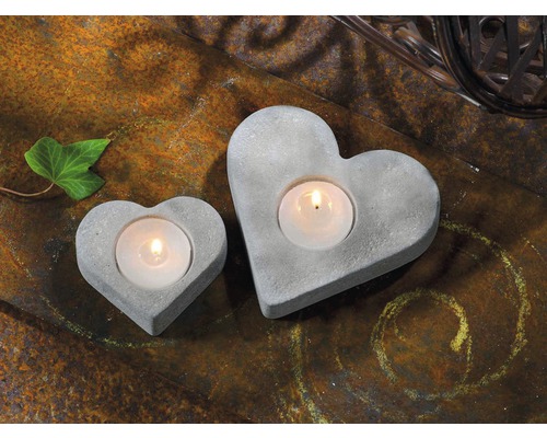 Twee hartvormige theelichthouders van beton op een rustieke ondergrond