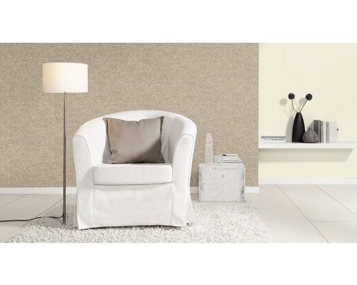 Woonkamer met fauteuil, staande lamp en behang met patroon