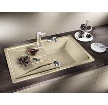 Spoelbak met afdruiprek, kraan, zeefmand, gebak en servies op een aanrecht