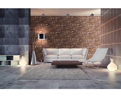 Woonkamer met bank, stoel, vloerkleed en bakstenen muur