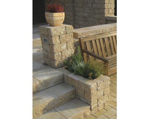 Buitenscène met stenen trap, stenen muur, houten bank en beplante stenen elementen