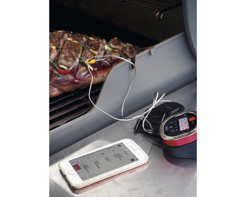 Grillthermometer in gebruik met vlees op de grill en smartphone-app voor temperatuurmonitoring