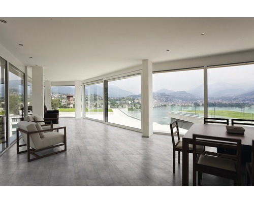 Lichte woonkamer met grote ramen en eethoek.