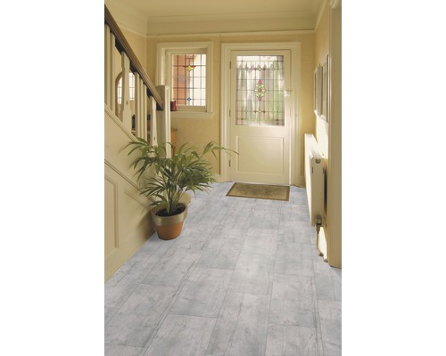 Lichte hal met laminaatvloer in steenlook, trap, deur en potplant
