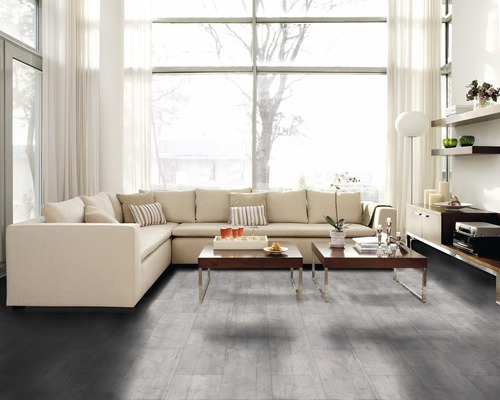 Lichte woonkamer met hoekbank, salontafels en houten vloer