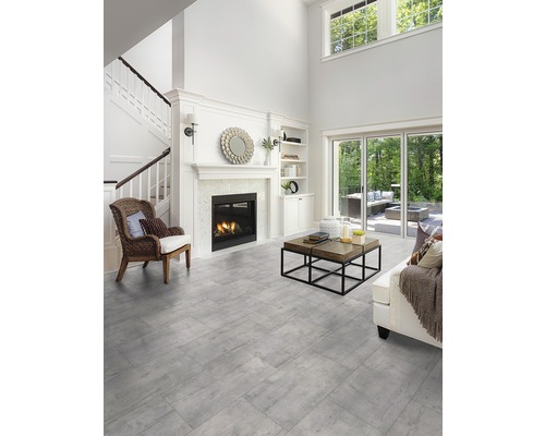 Lichte woonkamer met open haard, trap en grijze vloertegels
