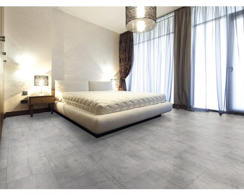 Lichte slaapkamer met tweepersoonsbed en een lichte tegelvloer met houtlook