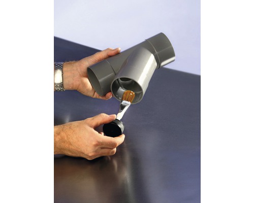 Gebruiker brengt lijm aan op een grijze kunststof buis met een penseel