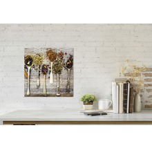 Decoratieve plaat met verschillende theesoorten in lepels op een houten achtergrond