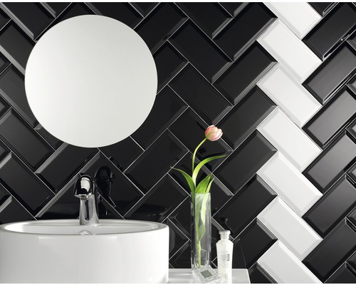 Badkamer met wastafel, spiegel en zwart-witte tegels in visgraatmotief