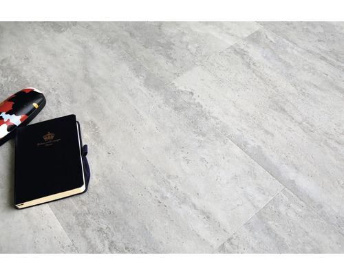 Grijze vloertegels met notitieboek en brillenkoker