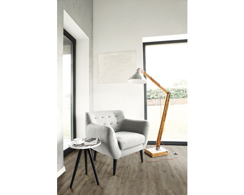 Lichte woonkamer met fauteuil, vloerlamp en bijzettafel op vloerbedekking