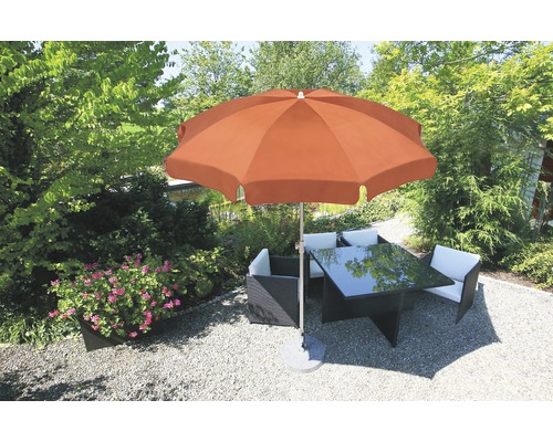 Tuinscene met een parasol, een tafel en stoelen.