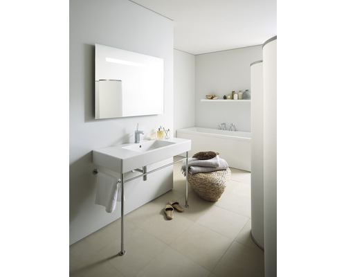 Lichte badkamer met wastafel op poten, spiegel, bad en decoratie