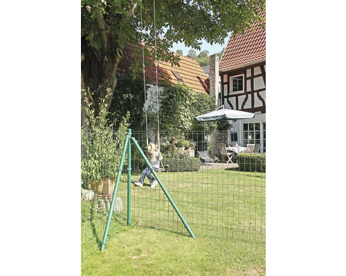 Tuinscène met kind op schommel achter een hek van gevlochten draad.