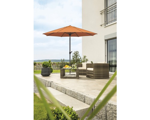 Terras met tuinscherm, tuinmeubelen en stenen treden voor een huis