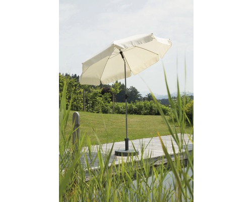Open parasol op een terras met een tuin op de achtergrond