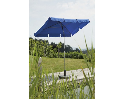 Blauwe parasol op een terras met gazon op de achtergrond.