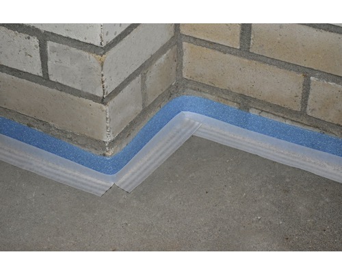 Detailopname van een plintisolatie op een bakstenen muur