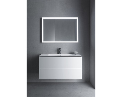 Badkamer met wastafelonderkast, wastafel en verlichte spiegel