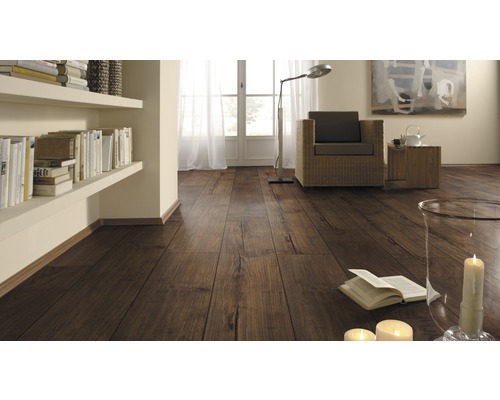 Woonkamer met laminaatvloer in houtlook, planken, fauteuil en decoratie