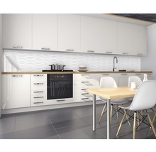 Moderne keuken met witte kasten, gootsteen, kookplaat, eettafel en gestructureerde wandbekleding.