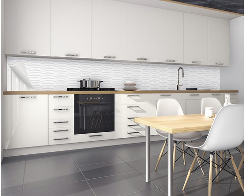 Moderne keuken met witte kasten, gootsteen, kookplaat, eettafel en gestructureerde wandbekleding.