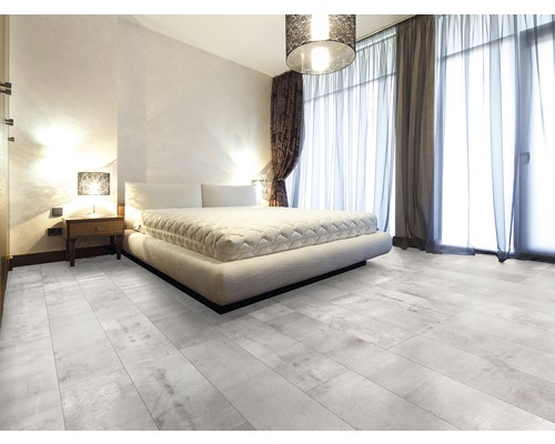 Lichte slaapkamer met tweepersoonsbed, nachtkastje, gordijnen en vloertegels met houtlook.