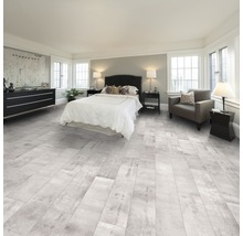 Slaapkamer met lichte houtlook vloer, bed en ladekast