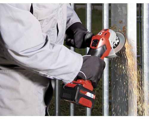 Iemand slijpt een metalen rooster met een draadloze haakse slijper, waarbij vonken ontstaan.