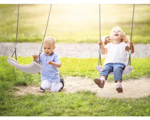 Twee kinderen spelen op een schommel in de buitenlucht.