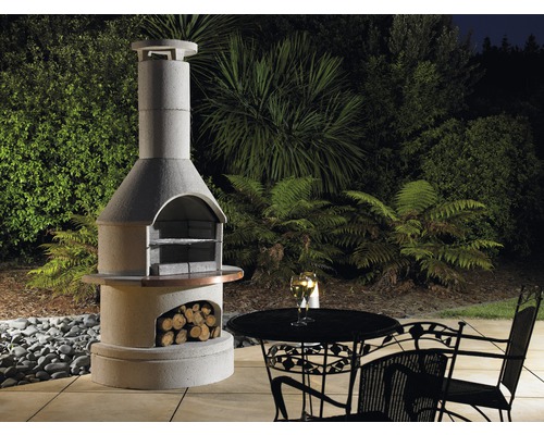 Gemetselde tuingrill met houtopslag, tafel en stoelen in de tuin