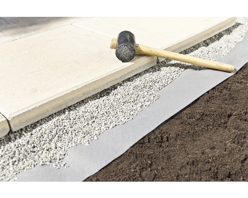 Bestrating, grind en een rubberen hamer op een worteldoek