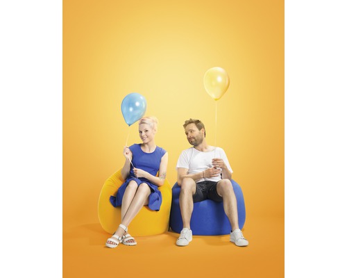 Een man en een vrouw zitten op zitzakken met ballonnen.