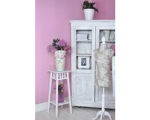 Decoratief interieur met kast, bloemenkruk en paspop in een heldere, vriendelijke ambiance.