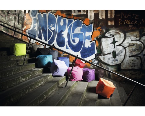 Meerdere zitkubussen op een trap voor een muur met graffiti
