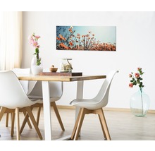 Eetkamer met houten tafel, witte stoelen en een bloemenschilderij aan de muur