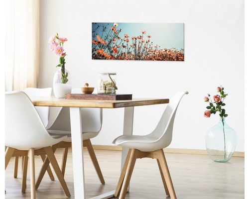 Eetkamer met houten tafel, witte stoelen en een bloemenschilderij aan de muur