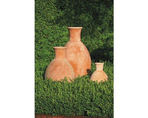 Drie terracotta plantenbakken van verschillende grootte in de tuin