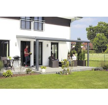 Terras met terrasoverkapping, tuinmeubelen en mensen voor een woonhuis