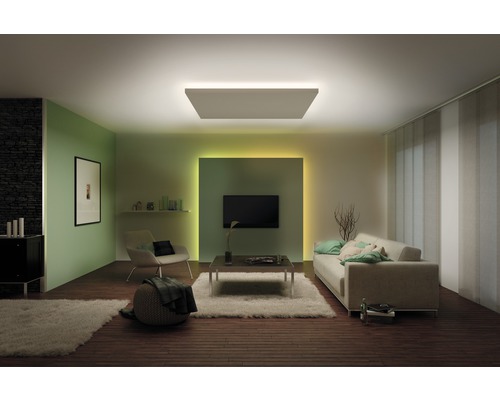 Woonkamer met plafondlamp, bank, stoel en televisie voor een lichte en gezellige sfeer