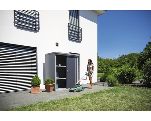 Tuinscene met gereedschapskast, grasmaaier en vrouw