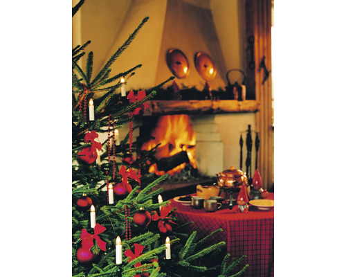 Kerstboom met versiering, verlichting en feestelijk gedekte tafel voor open haard