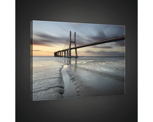 Canvas schilderij met een brug over zee in de schemering