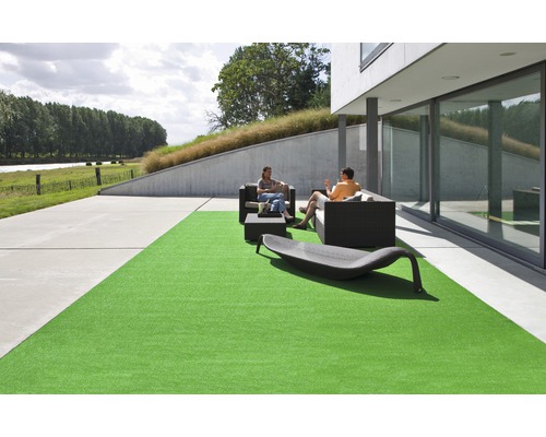 Tuinscène met kunstgras, zithoek en ontspanningsligstoel op terras