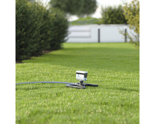 Tuinsproeier met slang op gazon