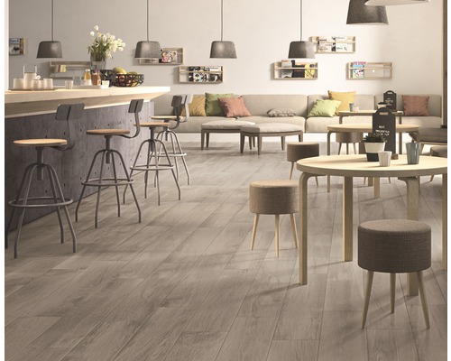 Interieur met houten vloer, barkrukken en tafels.